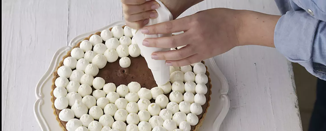 מעבירים את הקצפת לשק זילוף עם צנתר חלק ומזלפים תלוליות גדולות על גבי העוגה.