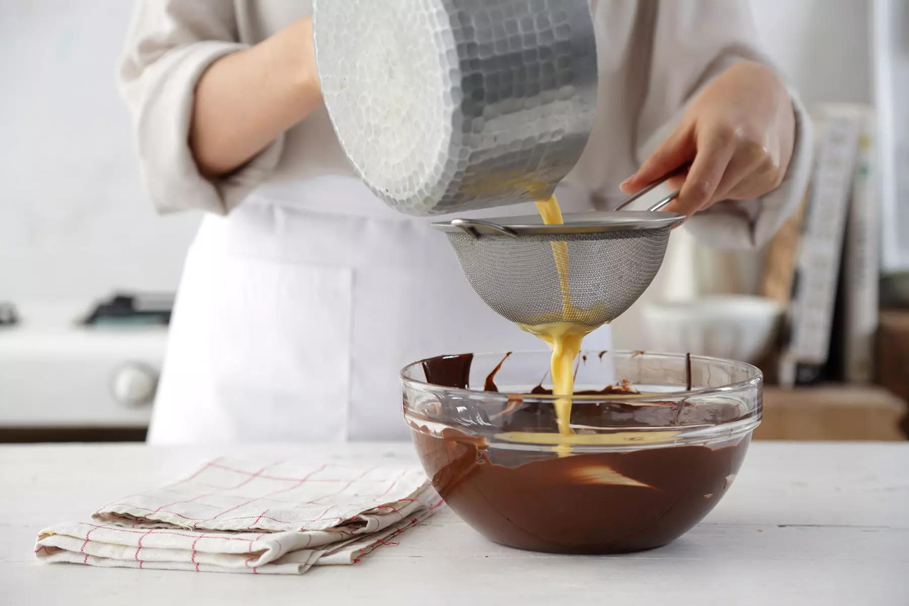 מסננים את הקרם מעל השוקולד המומס