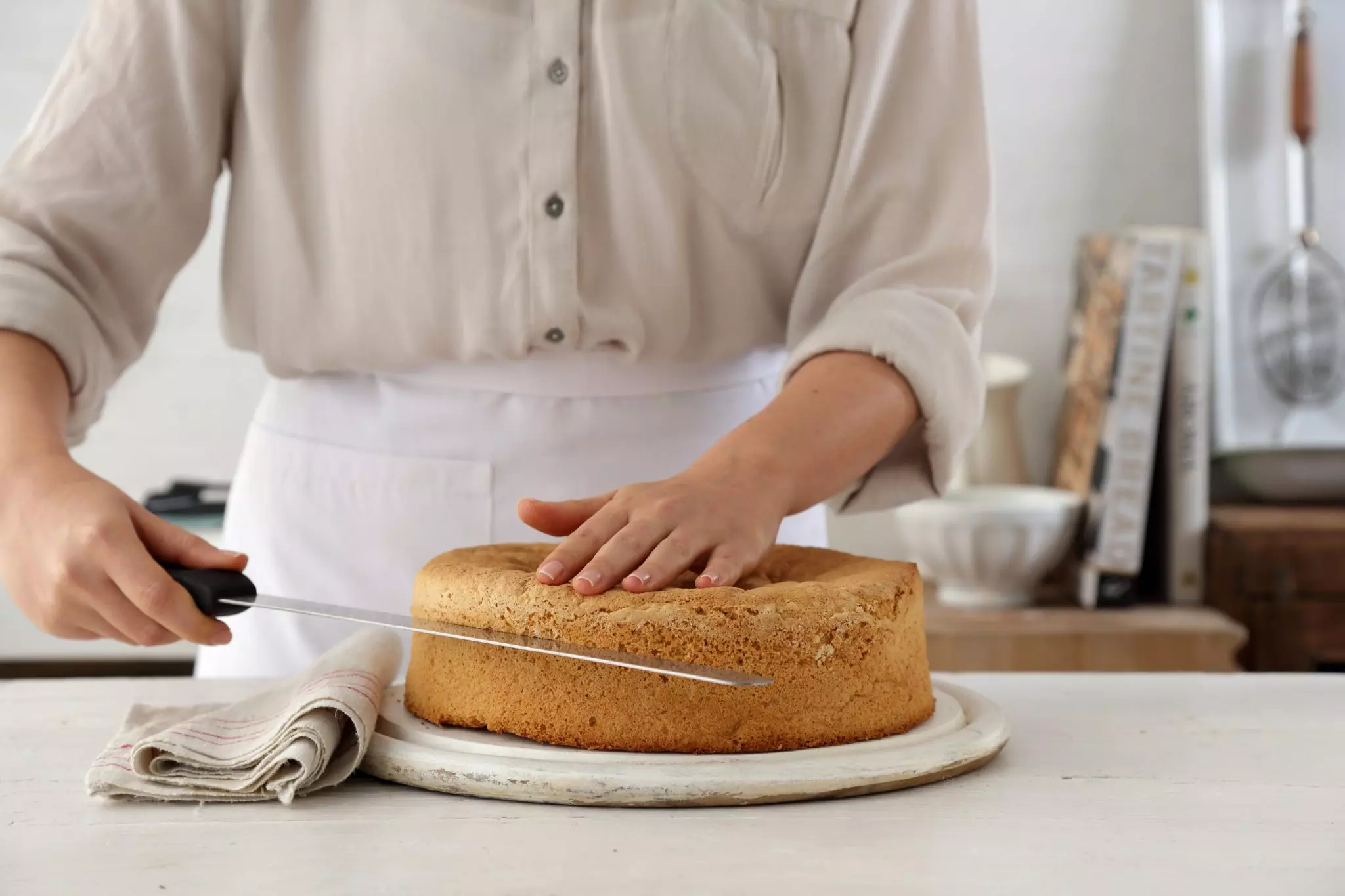 מצננים את העוגה לחלוטין, ופורסים לרוחבה לשלוש שכבות אחידות.