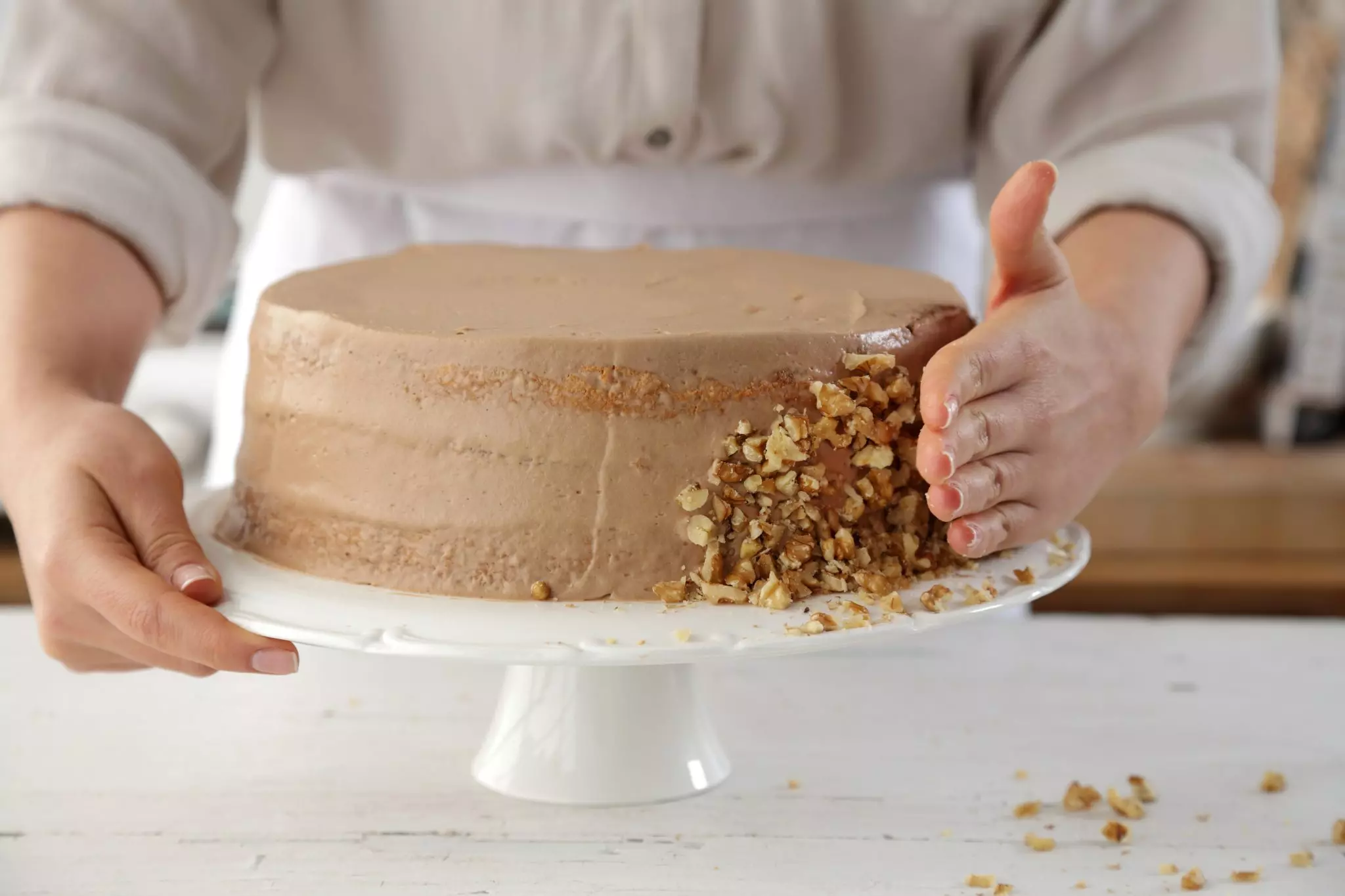 סוגרים בשכבה השלישית של העוגה, מברישים בסירופ ומצפים את העוגה בשאריות הקרם בדפנות ובחלק העליון בעזרת פלטה או קלף.