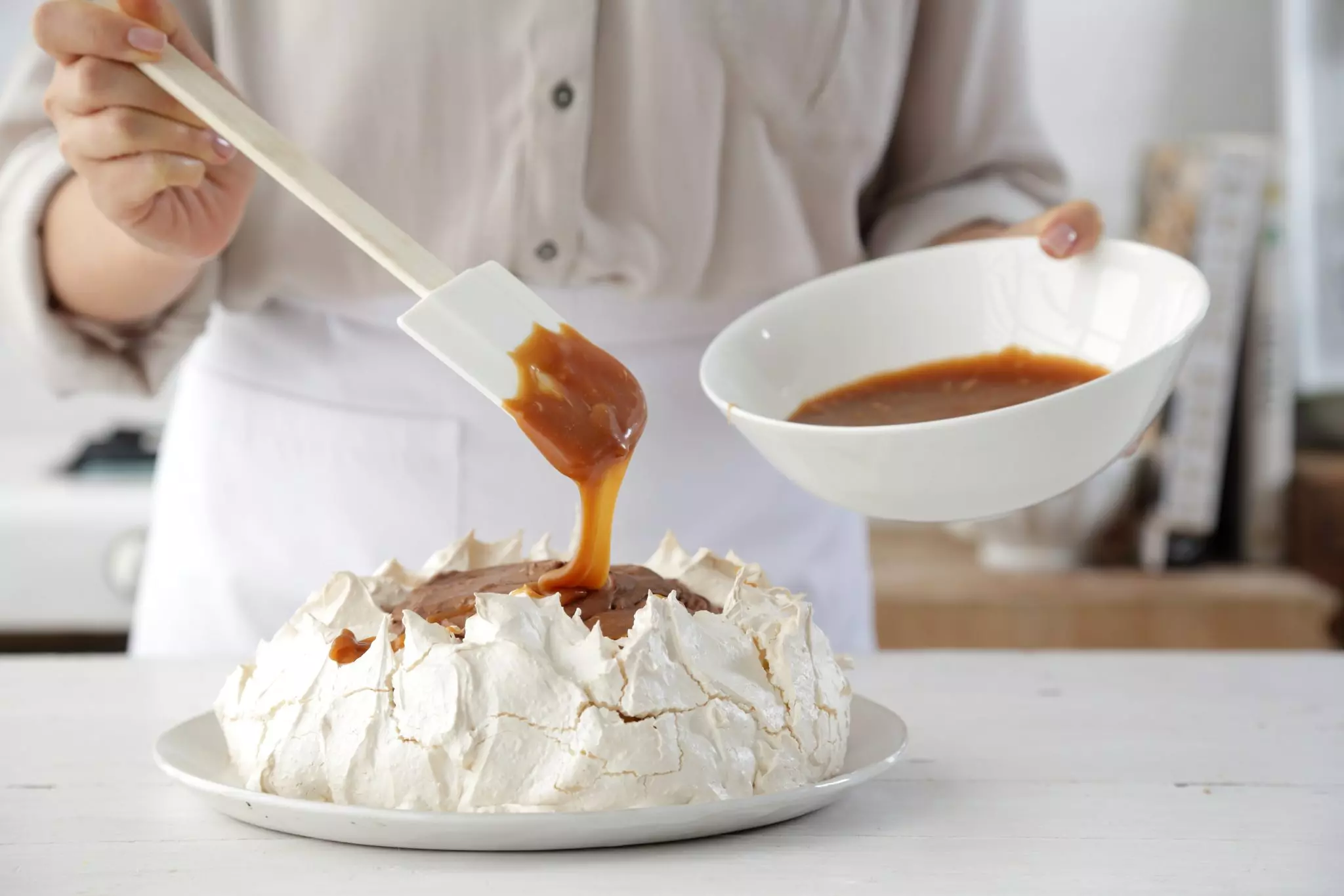 גישים את הפבלובה עם רוטב טופי נוזל ושוקולד קצוץ.