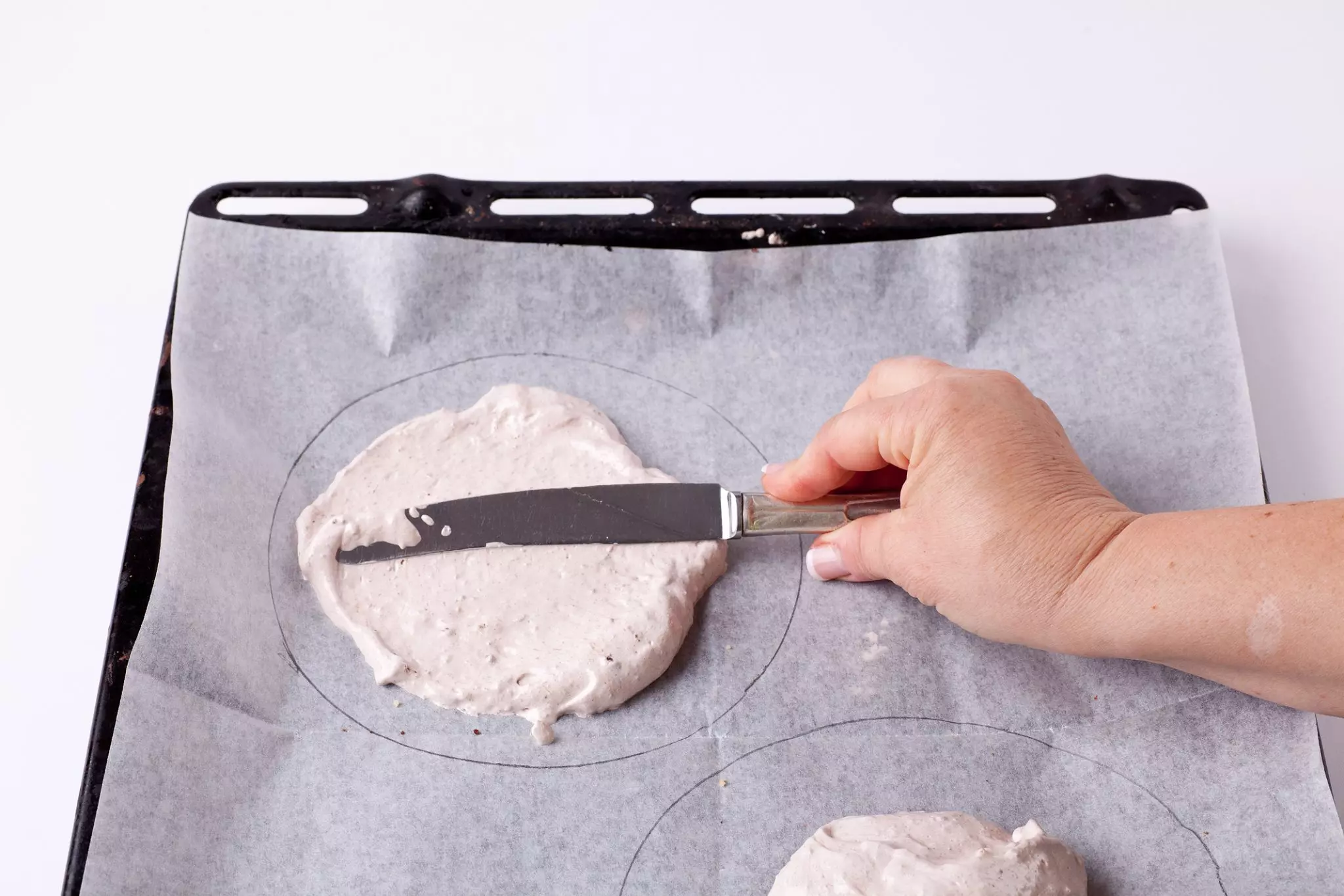 מניחים את העיסה במרכז העיגולים המצוירים ומשטחים.