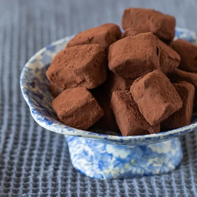 טראפלס קרמל מלוח שאי אפשר להפסיק לאכול. שילוב הטעמים משגע והאורחים לא יאמינו שהכנתם בבית ב-10 דקות💕
איך מכינים? 
מצרכים (ל45-50 יחידות):
400 גרם שוקולד פרה מריר, קצוץ גס
250 מ”ל שמנת מתוקה 38%
2 כפות סילאן

לקרמל מלוח:
1/2 כוס סוכר לבן
50 גרם חמאה
1/4 כוס שמנת מתוקה 38%
קורט מלח דק

לציפוי:
קקאו

אופן ההכנה:
- מניחים את השוקולד בקערה שמתאימה למיקרו ושופכים מעליו את השמנת. מחממים במיקרו, בפולסים של 40 שניות, ומערבבים בין חימום אחד לשני עד שנוצר רוטב מבריק.
- מוסיפים את הסילאן ומערבבים היטב. מעבירים את התערובת לתבנית מרובעל בגודל 20 ס”מ, משומנת היטב לקירור עד להתייצבות.
- מכינים את הקרמל: שמים את הסוכר בסיר בינוני עם תחתית עבה או במחבת רחבה, ומחממים על אש בינונית עד שהסוכר נמס והוא בצבע ענברי יפה.
- מוסיפים את החמאה ומערבבים (זהירות זה מבעבע) עד שהחמאה נמסה לגמרי.
- מוסיפים את השמנת ומערבבים עד שנוצר רוטב קרמל חלק. מורידים מהאש, מוסיפים את המלח ומערבבים.
- מוציאים מהמקרר את תערובת השוקולד, עושים שבילי קרמל מלוח ומערבבים באמצעות קיסם לדוגמת שיש ומחזירים לקירור.
- מחלצים את תערובת הטראפלס מהתבנית ובעזרת סכין טבולה במים חמים חותכים לקוביות בגודל 2 סנטימטר.
- מצפים בקקאו, מעבירים לקופסא אטומה ושומרים בקירור.