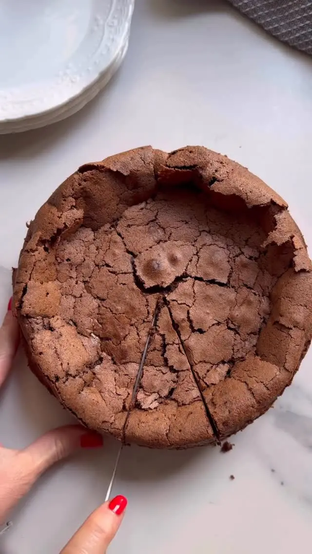 ה-עוגה שלכם לערב החג! 4 מצרכים, ללא גלוטן ומתקבלת עוגת פאדג’ שוקולד חלומית. המלצה שלנו: תגישו אותה עם קצפת לא ממותקת ותותים שנמצאים עכשיו בשיא והרי לכם קינוח מהאגדות💕 
מצרכים:
250 גרם שוקולד פרה מריר
120 גרם חמאה או שמן קוקוס
1/2 כוס סוכר לבן 
5 ביצים גודל L

אופן ההכנה:
- מחממים תנור ל-165 מעלות.
- בקערה גדולה שמתאימה למיקרו שמים שוקולד וחמאה וממיסים עד שנוצר רוטב שוקולד חלק. מצננים בצד. חשוב קערה גדולה כי לתוך הקערה הזאת יכנסו עוד מעט שאר המצרכים.
- מפרידים את הביצים לחלבונים (לבן) וחלמונים (צהוב) ומקציפים את החלמונים עם הסוכר במיקסר עם וו הקצפה עד שנוצר קרם בהיר ותפוח. שימו לב שזה לוקח באזור 5 דקות על מהירות בינונית אז סבלנות.
- לתוך קערת השוקולד מוסיפים 1/2 מכמות החלמונים המוקצפים ומקפלים. מוסיפים את יתרת הקציפה ושוב מקפלים בעדינות. זה בסדר אם נשארים שבילים קטנים בהירים זה תיכף שוב יתערבב ובכל מקרה עדיף לערבב פחות מאשר יותר.
- מנקים היטב את קערת המיקסר (אחרת אם ישאר שומן החלבונים לא יקציפו) ומקציפים את החלבונים עד שנוצר קצף יציב כמו קצפת יציבה.
- מוסיפים 1/2 מכמות החלבונים המוקצפים לבלילת השוקולד ומקפלים. מוסיפים את יתרת החלבונים ומקפלים בעדינות רק עד שאין יותר שבילים בהירים אלא מעין מוס שוקולד.
- משמנים תבנית בקוטר 20, עדיף עם נייר אפייה בתחתית, ומעבירים פנימה את הבלילה. אופים בתנור שחומם מראש ל-165 מעלות במשך 30 דקות. איך יודעים שהיא מוכנה? כשהיא מתחילה להסדק והשוליים נסדקים בעוד האמצע טיפל’ה רך.
- מצננים מעט ומעבירים למקרר ל-5 שעות או עד להגשה. אפשר להוסיף קצפת.